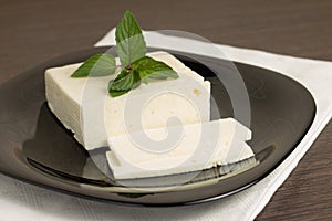 Sliced cheese on black dish with napkin