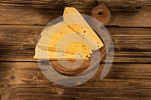 Sliced cheese on cutting board on wooden table