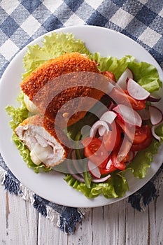 Sliced Chicken cordon bleu and salad close-up. vertical top view