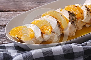 Sliced chicken fillet with orange sauce on a white plate