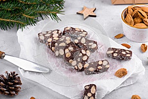 Sliced chocolate salami with almond on a baker paper, Christmas dessert