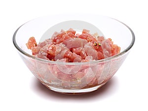 Sliced and chopped tuna fillet in glass bowl isolated on white background