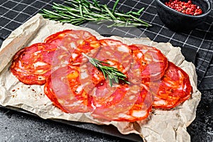 Sliced chorizo salami. Spanish traditional chorizo sausage. Black background. Top view