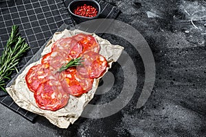 Sliced chorizo salami. Spanish traditional chorizo sausage. Black background. Top view. Space for text