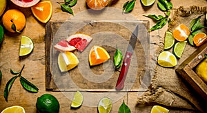 Sliced citrus fruits - grapefruit, orange, tangerine, lemon, lime on the old Board with box.