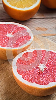 Sliced citrus fruits on a wooden table, orange and grapefruit