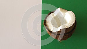 Sliced coconut on white and green background