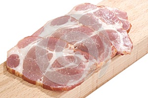Sliced cooked pork neck on a cutting board