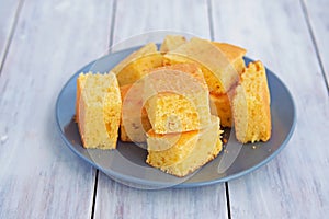 Sliced cornbread on a gray plate on a light wooden background. Corn flour recipes. C