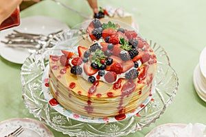 Sliced Crape Cake on top with Mixed Berries and Strawberry Sauce