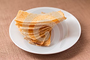 Sliced crispy bread in white ceramic dish.