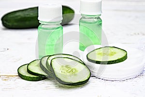 Sliced cucumber and a bottle of cucumber extract. Liquid cosmetics for skin care photo