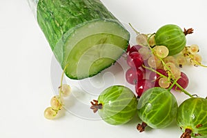 Sliced cucumber with red and white currants and green gooseberries