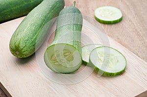 Sliced cucumber on wooden cutting board. View from front Sliced