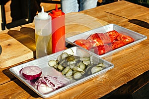 Sliced cucumbers, tomatoes in aluminum cuvettes.