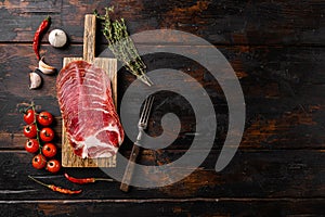 Sliced cured coppa ham, on old dark  wooden table background, top view flat lay, with copy space for text