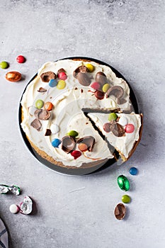Sliced Easter carrot cake decorated with candies and chocolate easter eggs
