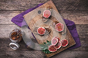Sliced figs and bread with jam on choppingboard in rustic style