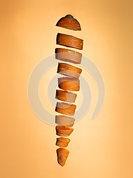 Sliced floating carrot on orange background