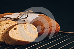 Sliced french baguette with crumbs on dark background