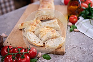 Sliced French bread baguette on wooden bread board