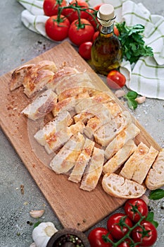 Sliced French bread baguette on wooden bread board