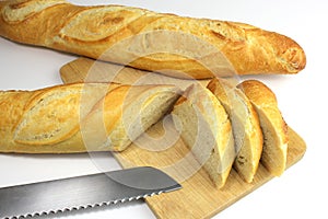 Sliced fresh baguette and bread knife