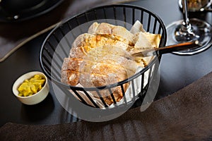 Sliced fresh baked artisan bread with butter in serving basket