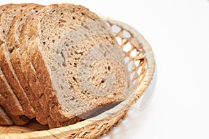 Sliced fresh bread in basket plate, isolated on white background, close up