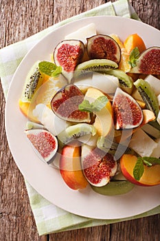 Sliced fresh fruit: figs, peaches, melons, kiwi and orange close
