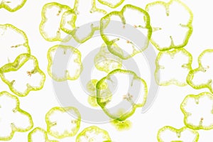 Sliced fresh green and red pepper rings on a white background. Decorative pattern. Food background.