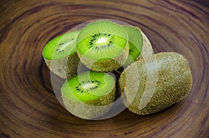 Sliced fresh and juicy kiwi fruit halves on a wooden background