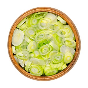 Sliced fresh scallions, chopped bulbs of green onions, in a wooden bowl