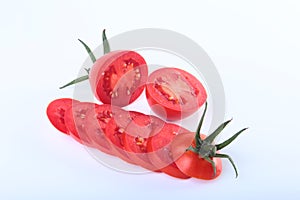 Sliced fresh tomatoes with green leaves on white background