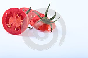 Sliced fresh tomatoes with green leaves on white background