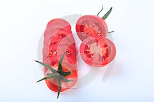 Sliced fresh tomatoes with green leaves on white background