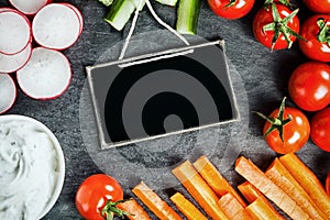 Sliced fresh vegetable frame around a slate