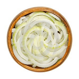 Sliced fresh white onions, cut into rings, in wooden bowl