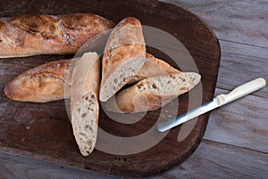 Sliced Freshly Baked Baguette on Wooden Board.