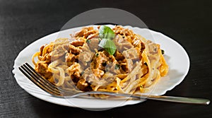 Sliced fried chicken breast meat in a creamy sauce with bavette pasta in a plate