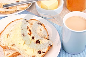 Sliced fruit loaf with sultanas and a cup of tea with milk