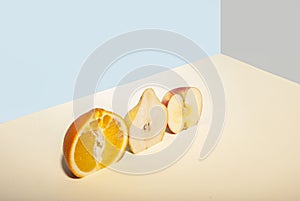 sliced fruits: orange, apple, pear. Exposed in a cut line, on a gray-blue background. Summer minimalism