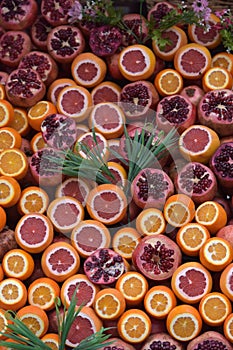 Oranges and pomegranates are sliced for juice