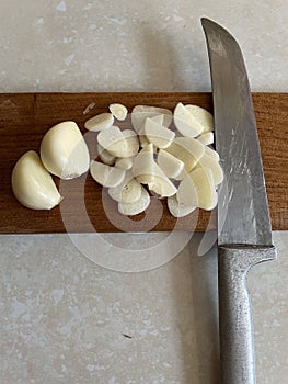 Sliced garlic on a cutting board.