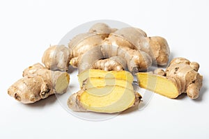 Sliced ginger beside fresh root