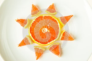 Sliced grapefruit on a white cutting board, sun rays