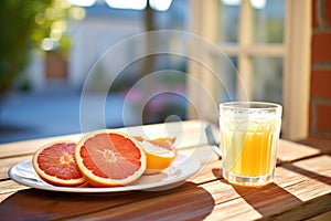 sliced grapefruits with a glass of juice on a sunny patio