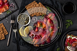 Sliced Gravlax,  scandinavian beet cured salmon  served with red onion, capers,  lemon and crisp bread photo