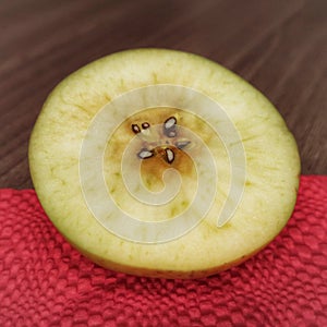 Sliced green apple on red napkin on the table