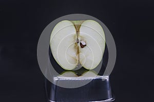 sliced green granny apple on a black background